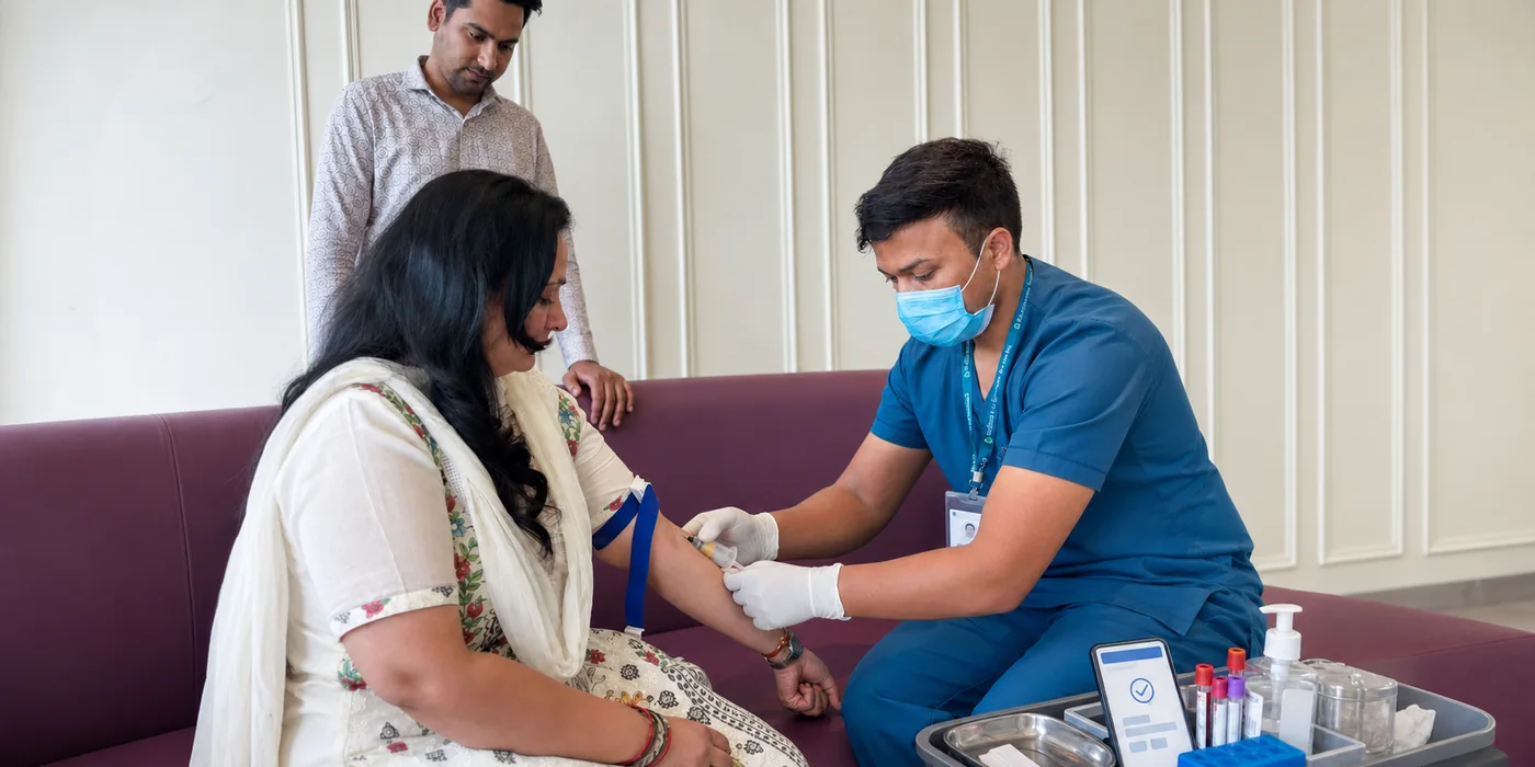 Uniformed phlebotomist with visible identification performing a hygienic home blood collection
